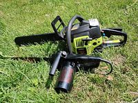 Poulan chainsaw and electric pole saw lying on grass
