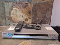 Front view of Sony DVP-NS325 player with remote and power cord on top