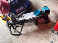 Overall view of Yardworks log splitter with manual on top and cords visible