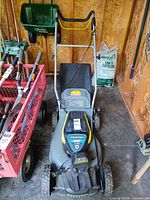 Front top view of Yardworks mower showing handle, deck and attached grass bag