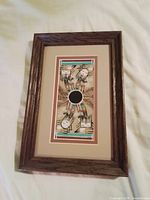 Full view of framed sandpainting showing frame, mat, and artwork
