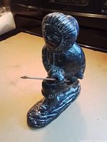 Full view of Inuit hunter sculpture with spear on base
