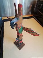 Front view of carved wooden totem pole on base