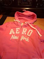 Front view showing full zip, logo, hood with drawstring