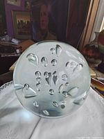 Front view of clear glass orb showing interior teardrop and round bubbles