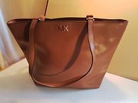 Front view showing acorn brown leather, MK logo, dual straps