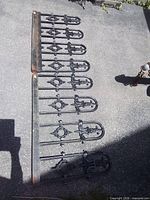 Both cast iron cresting panels laid out side by side showing full length and design