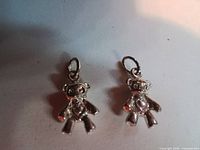 Front view of both teddy bear charms showing heart detail and jump rings