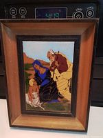 Front view of framed enamel plaque showing artwork and frame