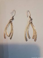 Full view of both sterling ribbon dangle earrings showing three curved bars and fishhook wires