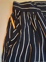Close-up of waistband, pleats, pocket depth with pencil