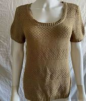 Front view of beige knit shirt on mannequin