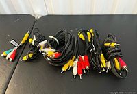 Group of coiled RCA cables with various colored connectors laid out on table