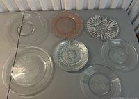 All eight vintage glass plates arranged on table