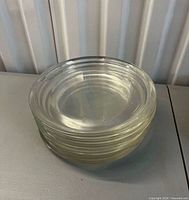 Stack of six clear glass plates