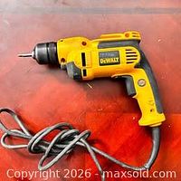 Full view of DeWalt yellow and black corded drill with cord coiled