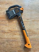 Full view of Fiskars X10 axe with sheath on wooden surface