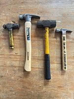 Four of the hammers laid out on workbench