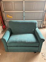 Front view of teal loveseat showing rolled arms, seat and back cushion, piping trim