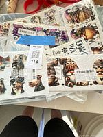 Pile of multiple vinyl sticker sheets with barcode labels showing gnomes and animal designs