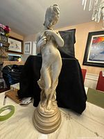 Full front view of resin female sculpture on pedestal