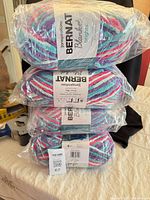 Four sealed skeins stacked showing Bernat Blanket Brights labels
