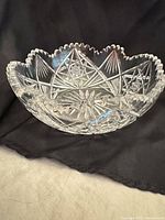 Full view of clear cut glass bowl showing scalloped rim and overall pattern