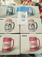 Fronts of six boxed Cricut mugs showing sample designs and capacity