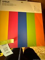 Front of Cricut Smart Paper Sticker Cardstock pack showing multicolor stripes and 10-sheet label