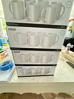 Stacked four boxes of Cricut 6-count mug packs