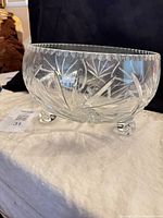 full view of clear cut crystal punch bowl on three scroll feet