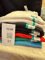 Stack of assorted-color Gildan XL T-shirts showing size stickers