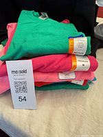 Stack of folded Gildan T-shirts with tag labels visible