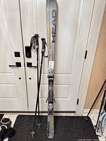 Full view of skis and poles leaning against door