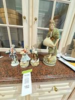 All four porcelain figurines on countertop