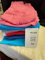 Stacked folded t-shirts various colors, lot overview