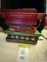 Stacked view of seven classic hardcover books showing top title The Wind in the Willows and overall quantity
