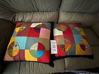 Both patchwork throw pillows on sofa with lot tag visible