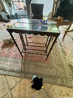 Larger table angled view showing mirrored top, scalloped apron, rod shelf