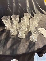 All nine crystal cordial glasses on black cloth