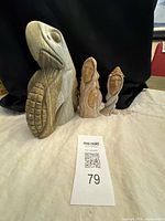 Front view of all three soapstone carvings with lot card