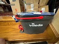 Side view of Vileda bucket showing logo, red handle, foot pedal