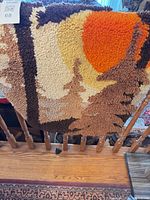 Front view of latch hook wall hanging showing full rustic tree and sun design
