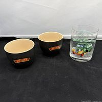 Two ceramic bowls and Hess glass side by side