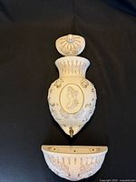 Three components of cream ceramic wall fountain laid out