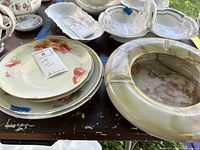 Stack of floral porcelain plates and green onyx ashtray on table