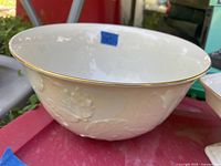 Exterior of Lenox ivory serving bowl showing embossed leaf design and gold rim