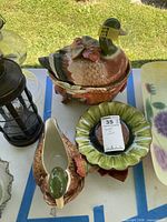 Overhead view of full set: duck tureen on base, gravy boat, green bowl, maple leaf plate