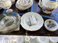 Group view of assorted porcelain and glass plates with display stand