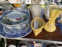 Vase and planter on display table with other items